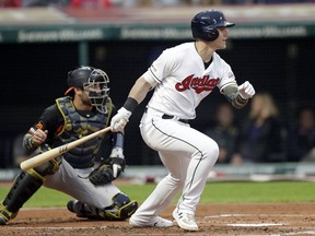 Cleveland Indians' Jake Bauers, right, watches his RBI-single off Baltimore Orioles starting pitcher Dylan Bundy as Orioles catcher Austin Wynns looks on in the second inning of a baseball game, Friday, May 17, 2019, in Cleveland. Jose Ramirez scored on the play.