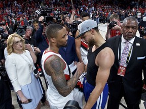 Golden State Warriors guard Stephen Curry, right, and Portland Trail Blazers guard Damian Lillard talk at the end of Game 4 of the NBA basketball playoffs Western Conference finals Monday, May 20, 2019, in Portland, Ore. The Warriors won 119-117 in overtime.