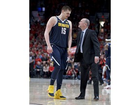 Denver Nuggets center Nikola Jokic, left, talks to head coach Michael Malone during the second half of Game 4 of an NBA basketball second-round playoff series against the Portland Trail Blazers, Sunday, May 5, 2019, in Portland, Ore. The Nuggets won 116-112.