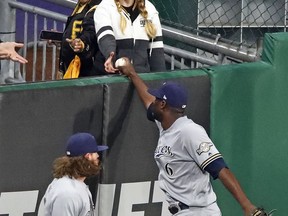 Milwaukee Brewers center fielder Lorenzo Cain (6) hands the ball to a fan after making the catch on a long fly ball to center field by Pittsburgh Pirates' Josh Bell to end a baseball game in Pittsburgh, Thursday, May 30, 2019. The Brewers won 11-5.