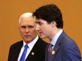 U.S. Vice President Mike Pence talks with Prime Minister Justin Trudeau as they arrive for the group photo at Americas Summit in Lima, Peru, in 2018.