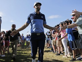 Dustin Johnson greets spectators as he walks to the 12th tee during the third round of the PGA Championship golf tournament, Saturday, May 18, 2019, at Bethpage Black in Farmingdale, N.Y.