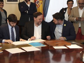 The leader of the Catalonian ERC party Oriol Junqueras, center, speaks with the ERC spokesperson for the parliament Gabriel Rufian, right, at the Spanish parliament in Madrid, Spain, Monday May 20, 2019. The five separatist leaders on trial for Catalonia's 2017 secession attempt who were elected to the Spanish Parliament in April 28 elections have been escorted by police to pick up their official parliament credentials. The Supreme Court is allowing the five politicians to get their credentials on Monday and attend the opening session of the new Parliament on Tuesday.