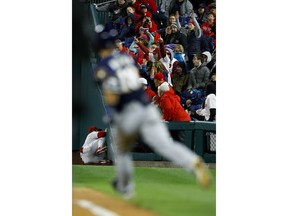 Philadelphia Phillies right fielder Bryce Harper, left, collides with the wall after catching a pop-foul by Milwaukee Brewers' Keston Hiura, right, during the sixth inning of a baseball game, Tuesday, May 14, 2019, in Philadelphia. Milwaukee won 6-1.