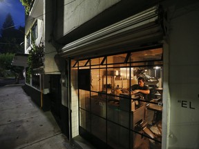 Chef Jesus Saldivar feeds ground corn through the tortilla making machine at El Pujol Mill in the Condesa neighborhood of Mexico City, Tuesday, April 9, 2019. The shop is part of a new tortilla movement launched by a handful of chefs, restaurants and organizations to restore and popularize authentic tortillas, made of only corn, water and lime or calcium carbonate.