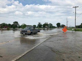 A pickup truck evacuates from an area in north Jefferson City Missouri as floodwaters from the Missouri River rise over the road on Friday, May 24, 2019.
