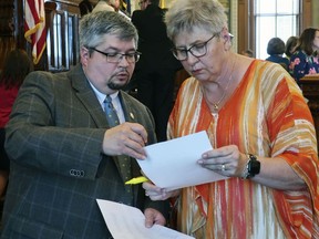 Kansas state Reps. Kyle Hoffman, left, R-Coldwater, and Brenda Landwehr, R-Wichita, review a tally of the House vote against a proposed $18.4 billion budget, Friday, May 3, 2019, at the Statehouse in Topeka, Kan. The budget narrowly failed because Democrats and moderate Republicans wanted to block it in hopes of forcing a Senate vote on Medicaid expansion.
