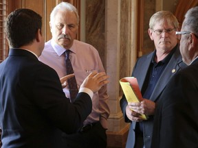 Republican members of the Kansas House confer as they wait for a vote on a proposed state budget, Saturday, May 4, 2019, at the Statehouse in Topeka, Kan. They are, from left to right, Reps. J.R. Claeys, R-Salina; John Resman, R-Olathe; Leo Delperdang, R-Wichita, and Emil Bergquist, R-Wichita.