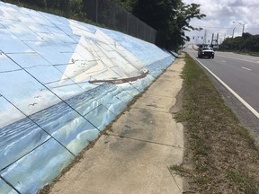 Traffic passes a mural along Africatown Boulevard in Mobile, Alabama, on Thursday, May 30, 2019. An archaeological report will be released Thursday, May 30, 2019 on the discovery of what experts believe is the last ship known to have brought enslaved people from Africa to the United States. The event in the Africatown community of Mobile also will include a community celebration and commemoration event marking the discovery of the schooner Clotilda , according to the Alabama Historical Commission.