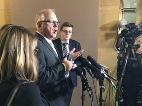 Democratic Minnesota Gov. Tim Walz, center, speaks with reporters during a break on budget talks at the State Capitol in St. Paul, Wednesday, May 15, 2019, as his press secretary, Teddy Tschann, right, looks on. Budget talks have resumed at the Minnesota Capitol, with Walz, House Democrats and Senate Republicans saying little publicly about their discussions. They're trying to complete a deal that would let the legislative session end as scheduled on Monday. The governor said Wednesday that the sides aren't saying much publicly because the talks are at "a really important time."