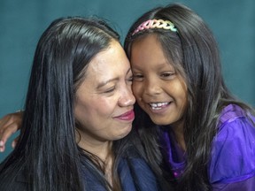 Vanessa Rodel embraces her daughter Keana, 7, at a news conference Wednesday, May 29, 2019 in Montreal. Rodel played a key role in whistleblower Edward Snowden's escape from U.S. authorities in Hong Kong.