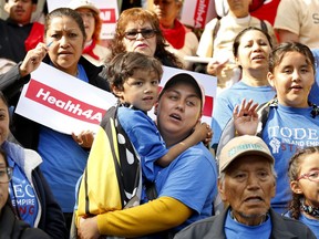 Oralia Sandoval, center, holds her son Benjamin, 6, as she participates in an Immigrants Day of Action rally, Monday, May 20, 2019, in Sacramento, Calif. Gov. Gavin Newsom has proposed offering government-funded health care benefits to immigrant adults ages 19 to 25 who are living in the country illegally. State Sen. Maria Elena Durazo, D-Los Angeles, has proposed a bill to expand that further to include seniors age 65 and older.