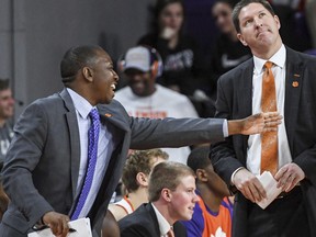 In this February, 2019 photo, Clemson assistant coach Steve Smith, left, gestures as head coach Brad Brownell, right, looks up, during an NCAA college basketball game in Clemson, S.C. Clemson has parted ways Smith on Friday, May 3, 2019, after his voice was heard on a federal wiretap involving defendant Christian Dawkins on the ongoing trial into college corruption.