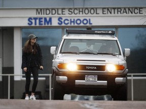 A young woman is dropped off outside the STEM Highlands Ranch school as she walks the parking lot to her vehicle Wednesday morning, May 8, 2019, in Highlands Ranch, Colo., the day after two students opened fire on students at the school.