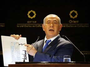 CORRECTS PHOTOGRAPHER TO ARIEL SCHALIT FROM SEBASTIAN SCHEINER - Israeli Prime Minister Benjamin Netanyahu shows a map from US President Donald Trump during statements to the press in Jerusalem, Thursday, May 30, 2019. President Donald Trump's son-in-law and senior adviser Jared Kushner met with Israeli Prime Minister Benjamin Netanyahu on Thursday to push the Trump administration's long-awaited plan for Mideast peace, just as Israel was thrust into the political tumult of an unprecedented second election in the same year.