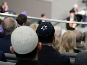 In this Thursday, Jan. 31, 2019, file photo, two men wearing skullcaps as they listen to the speech of Israeli Historian Saul Friedlaender, during a remembrance event of the parliament Bundestag to commemorate the victims of the Holocaust at the Reichstag building in Berlin.  Israeli President Reuven Rivlin said Sunday he is shocked by a statement by Felix Klein, the government's anti-Semitism commissioner, that he wouldn't advise Jews to wear skullcaps in parts of the country for their safety.