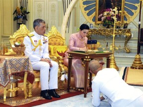 In this photo released by Bureau of the Royal Household ,Thailand's King Maha Vajiralongkorn Bodindradebayavarangkun, left, sits with Queen Suthida Vajiralongkorn Na Ayudhya as they sign their marriage certificates at Ampornsan Throne Hall in Bangkok, Thailand, Wednesday, May 1, 2019.Thailand's King Maha Vajiralongkorn, who will have his official coronation on Saturday, has appointed his consort as the country's queen. An announcement Wednesday in the Royal Gazette said Suthida Vajiralongkorn Na Ayudhya is legally married to the 66-year-old king, and is now Queen Suthida. (Bureau of the Royal Household via AP)