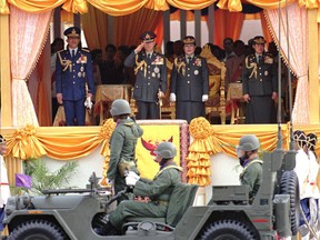 FILE - In this June 23, 1996, file photo, Crown Prince Maha Vajiralongkorn, left, and Thailand's King Bumibol Adulyadej, center, with Queen Sirikit, second right, and Princess Sirindhorn, right, salute Thai military officers before a military review in Bangkok, Thailand. Three days of elaborate centuries-old ceremonies begin Saturday, May 4, 2019, for the formal coronation of Thailand's King Maha Vajiralongkorn, who has been on the throne for more than two years. What Vajiralongkorn - also known as King Rama X, the 10th king of the Chakri dynasty - will do with the power and influence that venerated status confers is still not clear.