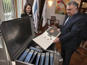 Israel's ambassador in Germany, Jeremy Issacharoff, right, holds documents prior to a handing over ceremony at the embassy of Israel in Berlin, Germany, Tuesday, May 21, 2019. German authorities are handing over to Israel some 5,000 documents kept by a confidant of Franz Kafka, a trove whose plight could have been plucked from one of the author's surreal stories.