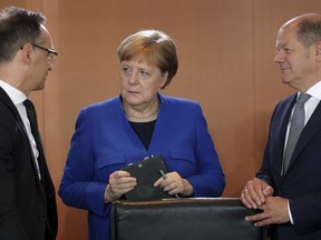 German Chancellor Angela Merkel, center,  German Foreign Minister Heiko Maas, left, and German Finance Minister Olaf Scholz talk as they arrive for the weekly cabinet meeting at the chancellery in Berlin, Germany, Wednesday, May 15, 2019.