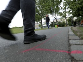 A man walks past a so called 'Drug Dealer Area' next to a traffic training course for kids at the public Goerlitzer Park in Berlin, Germany, Thursday, May 9, 2019.