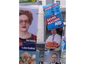 In this Friday, May 17, 2019 photo an AfD poster (top right) hangs on a street light during the street Europe and communal election campaigning of the far-right Alternative for Germany AfD in Gera, Germany. In Germany, the far-right AfD party is dominating the social media campaigns ahead of the European elections with attacks on the political establishment and fearmongering of migrants and Islam. The question is if their skilled digital campaigns will translate into a political success when Germany's voters cast their ballot on May 26.