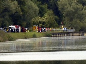 Rescue vehicles and police officers gather near Gerstheim, eastern France, Thursday, May 30, 2019. Police say three people were killed and a child disappeared after a small boat capsized in the Rhine River between Germany and France. (AP Photo)