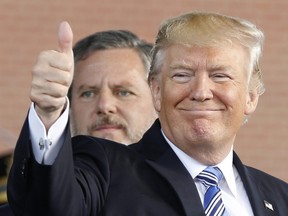 In this May 13, 2017 file photo, U.S. President Donald Trump, right, gives a thumbs up as Liberty University president, Jerry Falwell Jr., left, watches during of commencement ceremonies at the school in Lynchburg, Va.