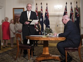 Australian Prime Minister Scott Morrison, second right, is sworn in by Governor-General Sir Peter Cosgrove, right, at Government House in Canberra, Wednesday, May 29, 2019. The 46th parliament is expected to open in the first week of July.