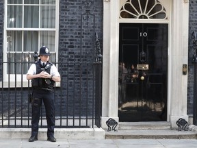 A police officer stands outside 10 Downing Street, the residence of British Prime Minister Theresa May, in London, England, Friday, May 24, 2019. Conservative lawmakers have given May until Friday to announce a departure date or face a likely leadership challenge.