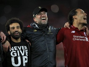 Liverpool's Mohamed Salah, left, manager Jurgen Klopp, center, and Virgil van Dijk celebrate after the Champions League Semi Final, second leg soccer match between Liverpool and Barcelona at Anfield, Liverpool, England, Tuesday, May 7, 2019. Liverpool won the match 4-0 to overturn a three-goal deficit to win the match 4-3 on aggregate.