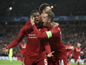 Liverpool's Georginio Wijnaldum, left, celebrates scoring his side's third goal of the game during the Champions League Semi Final, second leg soccer match between Liverpool and Barcelona at Anfield, Liverpool, England, Tuesday, May 7, 2019.