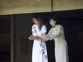 U.S. first lady Melania Trump, left, and  Japanese Prime Minister Shinzo Abe's wife Akie Abe look at koi carps in a pond at the Japanese style annex inside the State Guest House in Tokyo Monday, May 27, 2019.