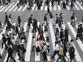 In this April 15, 2019, photo, people cross the street in Tokyo. The Japanese government says the economy grew at an annual pace of 2.1% in the first quarter, marking the second straight quarter of expansion. The Cabinet Office said Monday, May 20, 2019, seasonally adjusted real gross domestic product, the total value of a nation's goods and services, grew 0.5% in the January-March period from the previous quarter.