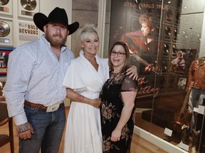 In this April 30, 2019, photo, Lorrie Morgan poses with her son, Jesse Keith Whitley, left, and adopted daughter Morgan Whitley, right, at the Keith Whitley exhibit at the Country Music Hall of Fame and Museum in Nashville, Tenn. Keith Whitley seemed destined for greatness, but his life was cut tragically short at the age of 33 because of his alcohol addiction. Morgan, his widow, said she hopes people see the struggles he endured to live his dream. Jesse Keith Whitley is the son of Lorrie Morgan and Keith Whitley, and Morgan Whitley is the daughter of Keith Whitley, adopted by Lorrie Morgan.