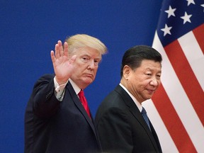 This file picture taken on November 9, 2017 shows U.S. President Donald Trump, left, and China's President Xi Jinping leaving a business leaders event at the Great Hall of the People in Beijing.