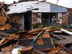 Wesley Mantooth lifts a wooden chair out a window of the home of his father, Robert, in Abilene, Texas, on Saturday, May 18, 2019. Many residents said a tornado struck in the early morning hours.