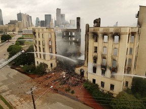 Dallas firefighters pour water on the destroyed historic Ambassador hotel just south of downtown Dallas, Tuesday, May 28, 2019. Over 100 firefighters responded to the four-alarm fire.