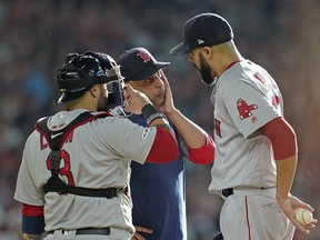 Boston Red Sox manager Alex Cora, center, talks with starting pitcher David Price, right, as catcher Sandy Leon (3) joins them on the mound during the first inning of a baseball game against the Houston Astros Saturday, May 25, 2019, in Houston. Price left the game after their discussion.