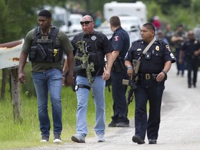 Law enforcement arrive on scene as they investigate a home where they believe the suspect's vehicle from an officer involved shooting is parked, Wednesday, May 29, 2019, in Cleveland. Police are searching for a man they say killed a woman and wounded three people, including a sheriff's deputy, during shootings in East Texas.