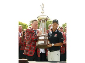 Kip Adams, left, president of Colonial Country Club, presents Kevin Na with the Leonard Trophy after Na won the Charles Schwab Challenge golf tournament Sunday, May 26, 2019, in Fort Worth, Texas.