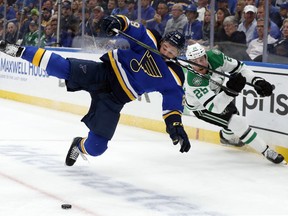St. Louis Blues defenseman Vince Dunn (29) and Dallas Stars right wing Brett Ritchie (25) compete for control of a loose puck during the first period in Game 7 of an NHL second-round hockey playoff series, Tuesday, May 7, 2019, in St. Louis.