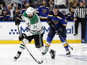 Dallas Stars' Jamie Benn (14) shoots the puck as St. Louis Blues' Sammy Blais (9) looks on during the second overtime period in Game 7 of an NHL second-round hockey playoff series, Tuesday, May 7, 2019, in St. Louis.