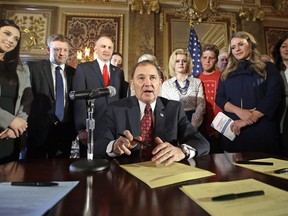 FILE - In this April 19, 2016, file photo, Utah Gov. Gary Herbert looks up during a ceremonial signing of a state resolution declaring pornography a public health crisis, at the Utah State Capitol, in Salt Lake City. More than a dozen states have moved to declare pornography a public health crisis, encouraging supporters but raising concerns among experts who say the label goes too far and carries its own risks. Arizona became the latest of 16th state to pass a resolution in at least one legislative chamber on Monday, May 6, 2019, calling for a systemic effort to prevent exposure to porn that's increasingly accessible to kids at younger ages online.