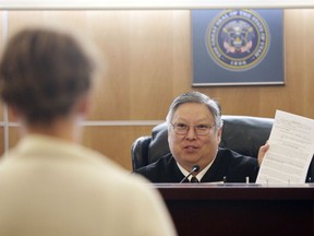 FILE - In this May 25, 2010, file photo, Judge Michael Kwan talks with a defendant during drug court in Taylorsville, Utah. Kwan, a longtime Utah judge has been suspended without pay for six months for comments he made online and in court criticizing President Donald Trump that the state's supreme court determined violated the judicial code of conduct. The Utah Supreme Court said in a decision posted Wednesday, May 22, 2019, that Judge Michael Kwan's numerous online posts in 2016-2017 criticizing Trump diminished "the reputation of our entire judiciary."