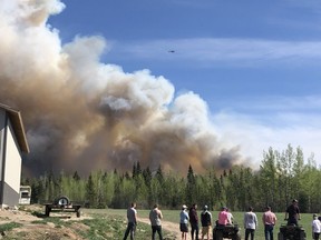 People watch a wildfire burn in Fraser Lake, B.C., Saturday, May 11, 2019. An active wildfire in central British Columbia has prompted a local state of emergency and several evacuations. THE CANADIAN PRESS/HO