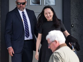 Huawei chief financial officer Meng Wanzhou, back right, who is out on bail and remains under partial house arrest after she was detained Dec. 1 at the behest of American authorities, is accompanied by a private security detail as she leaves her home to attend a court appearance in Vancouver, on Wednesday, May 8, 2019.