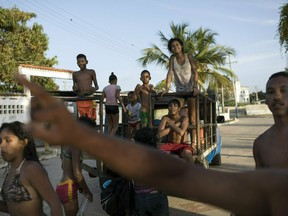 Residents return home after a day at the beach in Machurucuto, Venezuela, Sunday, May 5, 2019. Fifty-two years ago this month an expeditionary force of 12 guerrillas departed from the communist-run island and days later landed in this sleepy fishing village with the goal of spreading Fidel Castro's revolution to South America.