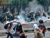 Anti-government protesters clash with security forces in the surroundings of La Carlota military base in Caracas during the commemoration of May Day on May 1, 2019.