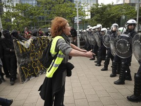 A yellow vest protestor talks to a line of police officers during a demonstration in Brussels, Sunday, May 26, 2019. The demonstration took place as Belgium took to the polls to elect regional, national and European candidates.